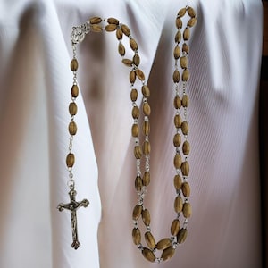May include: A wooden rosary with brown beads and a silver crucifix.