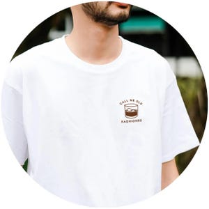 May include: White t-shirt with a brown graphic of a glass of whiskey with ice and the text "Call me old fashioned".