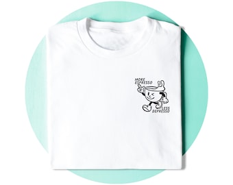 Könnte beinhalten: Weißes T-Shirt mit einem schwarzen Cartoon-Kaffeetassen-Charakter und dem Text "MORE ESPRESSO LESS DEPRESSO". Das T-Shirt ist gefaltet und vor einem hellblauen Hintergrund platziert.