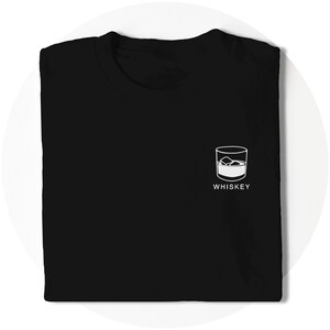 K&ouml;nnte beinhalten: Schwarzes T-Shirt mit einer wei&szlig;en Grafik eines Glases Whisky mit Eisw&uuml;rfeln und dem Wort "WHISKEY" darunter.