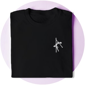 以下が含まれることがあります： 白いスケルトンポールダンサーのグラフィックが前面に描かれた黒いTシャツ。 シャツは折りたたまれ、白い円のある薄紫色の背景に配置されています。 デザインはミニマリストのイラストです。