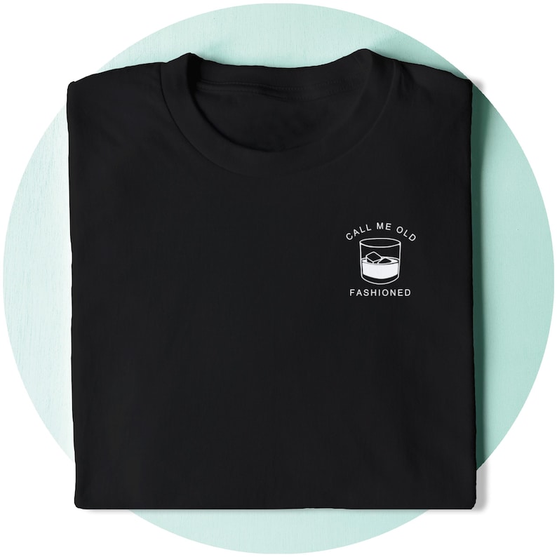 May include: Black t-shirt with white text that reads "Call me old fashioned" and a graphic of a glass of whiskey with ice cubes.