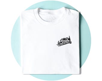 Op de afbeelding: Een wit t-shirt met korte mouwen en een kleine zwarte afbeelding van een stoomlocomotief op de rechterkant van de borst. Het shirt heeft een ronde hals en is netjes opgevouwen, waardoor de treinillustratie duidelijk zichtbaar is.