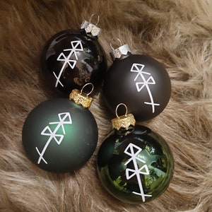 Könnte beinhalten: Vier Weihnachtskugeln in Schwarz und Grün mit einem weißen geometrischen Muster.