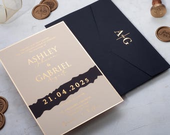 Invitación de boda personalizada en color beige con sobre negro y monograma en lámina dorada.