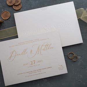 Elegante conjunto de invitaciones de boda color marfil con lámina dorada, tarjetas con relieve champán, invitaciones de boda premium gruesas para eventos formales.