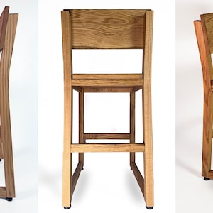 May include: Wooden bar stool with a rectangular seat and backrest. The stool is constructed from light and dark brown wood, with a simple, modern design. The stool's height is approximately 102 cm.