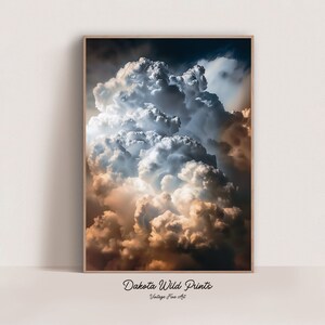 May include: A photograph of a large, fluffy cloud formation in the sky. The clouds are a mix of white, gray, and light blue, with a hint of orange at the bottom. The clouds are illuminated by the sun, creating a dramatic and beautiful scene.