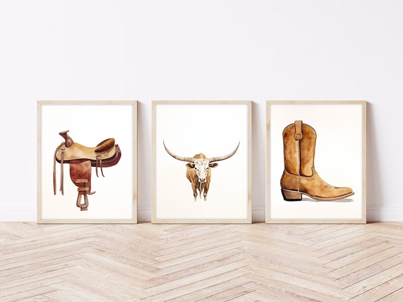May include: Three watercolour paintings in wooden frames. The first painting shows a brown leather saddle. The second painting shows a white and brown longhorn steer. The third painting shows a brown cowboy boot.