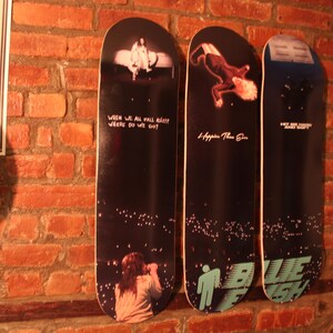 Puede incluir: Tres tablas de skate negras y blancas con dise&ntilde;os gr&aacute;ficos. La primera tabla tiene el texto "When we all fall asleep where do we go?" La segunda tabla tiene el texto "I hope you're the one." La tercera tabla tiene el texto "Why are you so sad?" y un gr&aacute;fico azul y blanco.