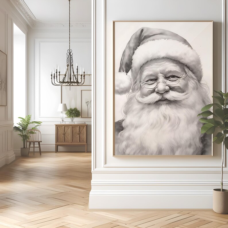 May include: A framed black and white portrait of Santa Claus. The artwork depicts Santa with a long white beard, round glasses, and a traditional hat. The portrait is displayed in a room with a chandelier, wooden floors, and a plant.