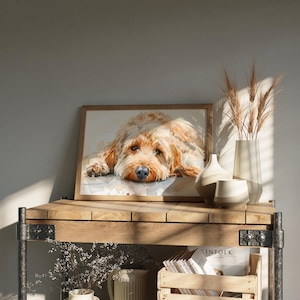 May include: A framed watercolor painting of a brown and white dog with its head resting on its paws. The painting is on a wooden shelf with a vase of dried wheat and other decorative items.
