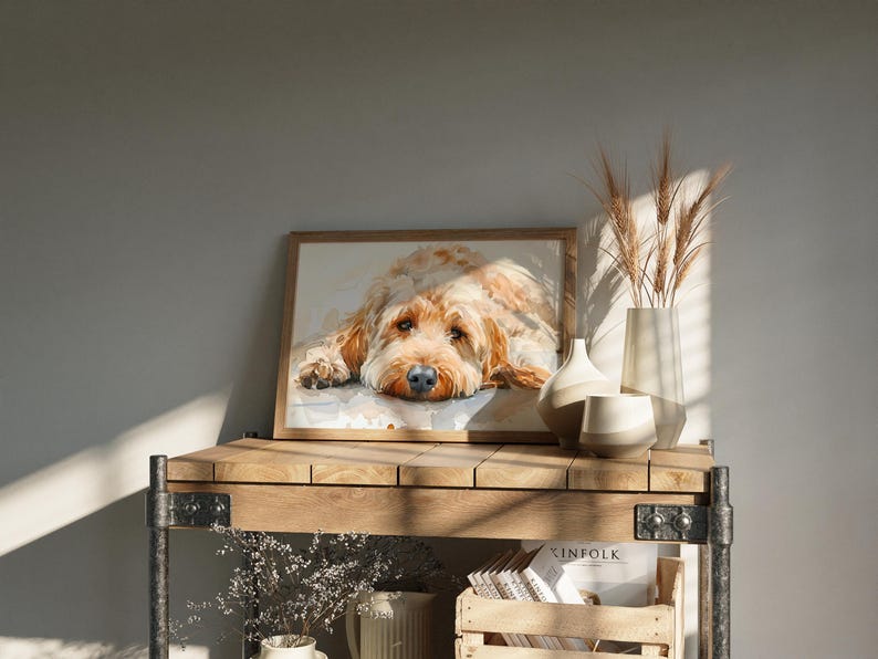 May include: A framed watercolor painting of a brown and white dog with its head resting on its paws. The painting is on a wooden shelf with a vase of dried wheat and other decorative items.