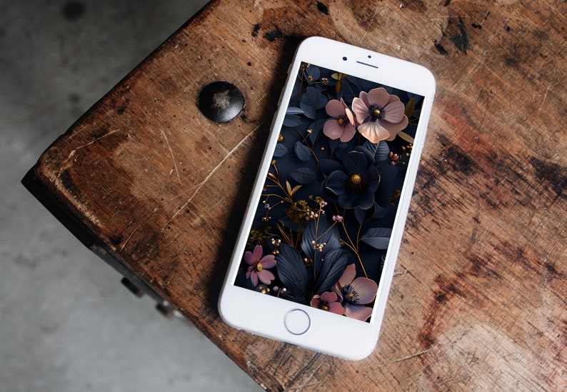 May include: A white smartphone with a floral phone case. The case features a dark background with pink and gold flowers.