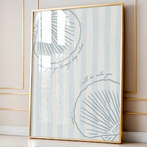 Può includere: Una stampa artistica incorniciata con uno sfondo a righe blu chiaro e bianco, con due illustrazioni di conchiglie. L'opera d'arte include il testo "when you go through deep waters, I will be with you" e "Isaia 43:2". La cornice è dorata.