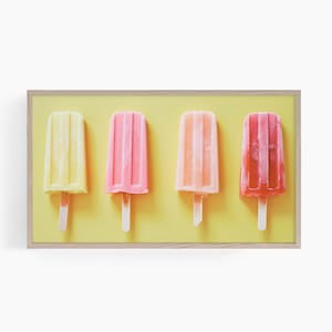 May include: Four popsicles in a wooden frame on a yellow background. The popsicles are yellow, pink, orange, and red.