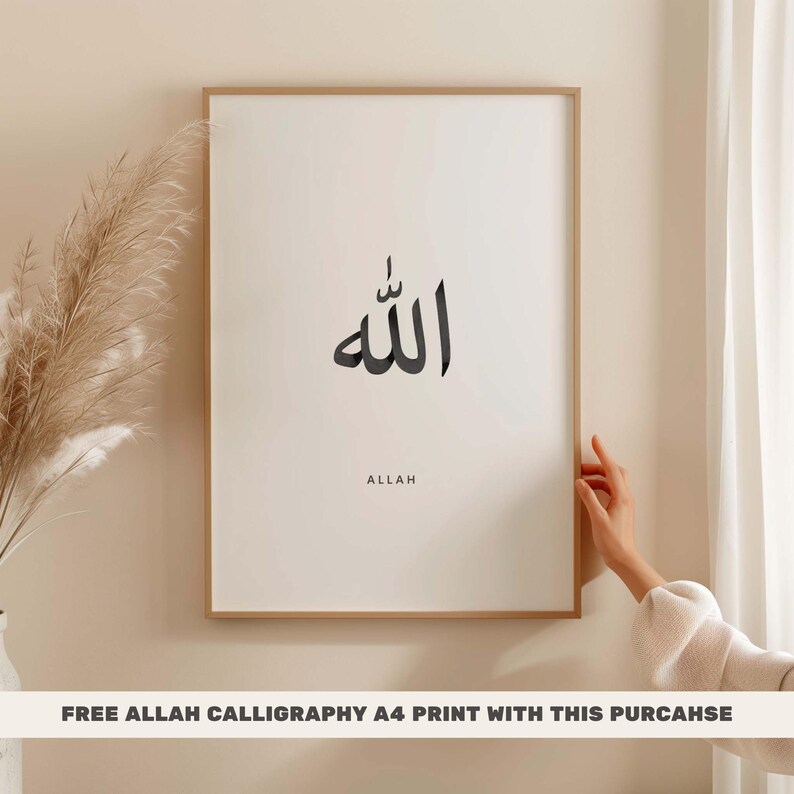 Op de afbeelding: Een ingelijste print met een zwart kalligrafieontwerp van het woord "Allah" in Arabisch schrift. Het woord "Allah" staat in het Engels onder het Arabische schrift.