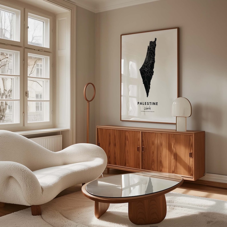 Op de afbeelding: Een witte bank met een houten salontafel ervoor. Achter de bank staat een houten kast met twee deuren. Aan de muur boven de kast hangt een zwart-witte kaart van Palestina. De kaart is ingelijst in een houten lijst.