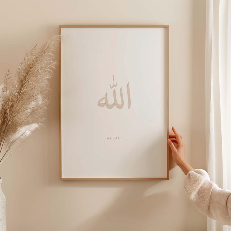May include: A framed print featuring the Arabic word "Allah" in a light brown colour, with the word "Allah" written in English below it.