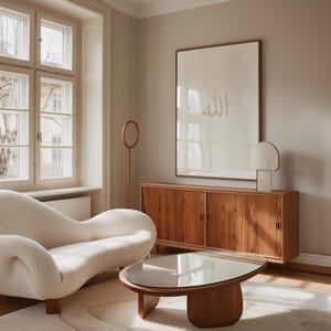 May include: A white sofa with a curved design sits in a living room with a wooden cabinet and a glass coffee table. A framed print with the word "Allah" in Arabic script hangs on the wall.