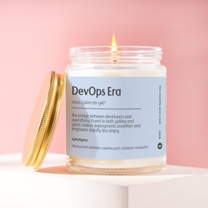 May include: A lit candle in a glass jar with a gold lid. The label reads "DevOps Era" with a definition and synonyms. The candle sits on a white surface against a pink background.
