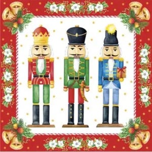 May include: A square decorative napkin featuring three nutcracker figures in red, green, and blue uniforms. The border is red with white flowers, green leaves, and gold bells in the corners. The background is white with small gold dots.