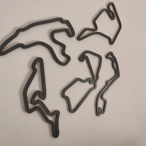 Pode incluir: Arte de parede de contorno preto e branco de uma pista de corrida. A pista é feita de madeira e tem a forma de um circuito.