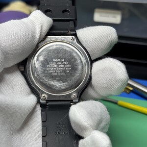 Peut inclure: Une montre Casio MW-240 noire avec un dos en acier inoxydable. La montre a un bracelet en caoutchouc noir et est r&eacute;sistante &agrave; l'eau. Le texte au dos indique "CASIO", "WATER RESISTANT 5BAR" et "JAPAN MOV'T".