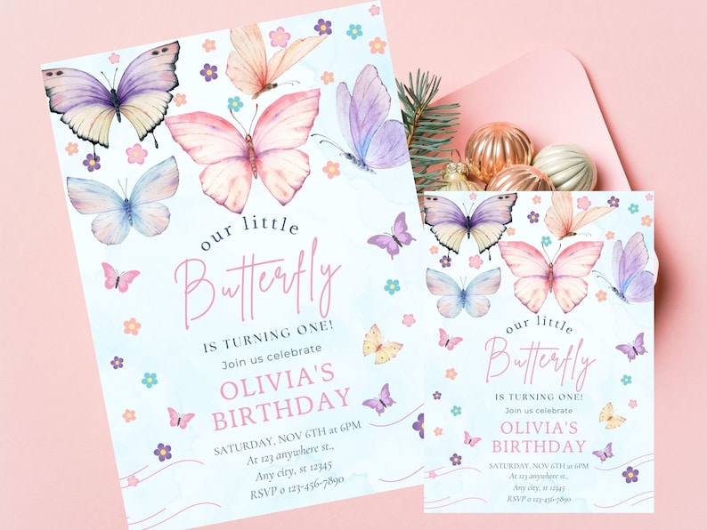 Puede incluir: Una invitaci&oacute;n de cumplea&ntilde;os azul y rosa con un dise&ntilde;o de mariposa de acuarela. La invitaci&oacute;n dice "&iexcl;Nuestra peque&ntilde;a mariposa cumple un a&ntilde;o!" e incluye el texto "El cumplea&ntilde;os de Olivia".