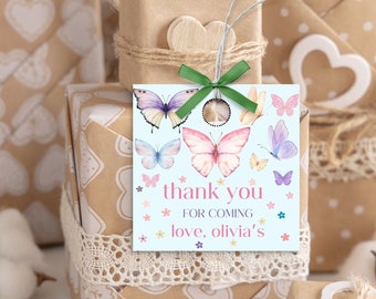 May include: A light blue thank you tag with a butterfly theme. The tag has a white border and features colorful butterflies, flowers, and the text "thank you for coming love, olivia's".