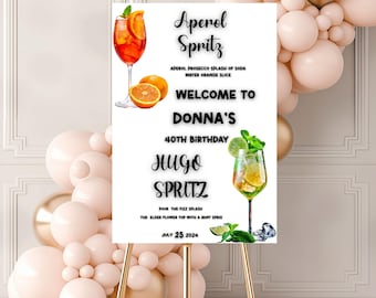 May include: A white sign on a gold easel, featuring the text "Aperol Spritz" and "Hugo Spritz." The sign welcomes guests to Donna's 40th birthday on July 25, 2024. Illustrations of cocktails and oranges are included.