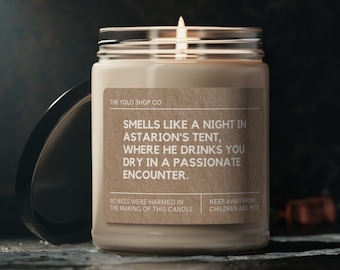 May include: A brown glass candle jar with a brown paper label that reads "Smells like a night in Astarion's tent, where he drinks you dry in a passionate encounter." The label also says "No bees were harmed in the making of this candle" and "Keep away from children and pets".