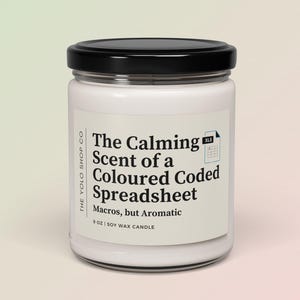 Peut inclure: Une bougie en cire de soja blanche dans un bocal en verre avec un couvercle noir. L'étiquette indique "The Calming Scent of a Coloured Coded Spreadsheet" avec le texte "Macros, but Aromatic". La bougie pèse 255 grammes.
