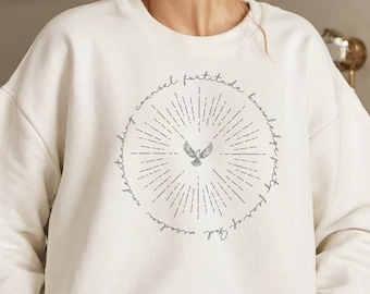 May include: White sweatshirt with a circular design featuring a dove in flight and the words "cancel fear, fortitude, knowledge, spirit, grace of God, wisdom, understanding".