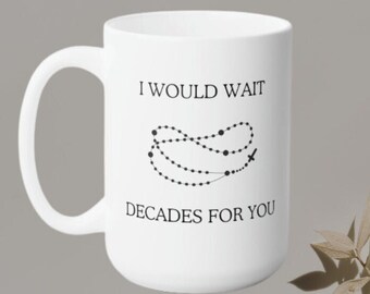 May include: White ceramic mug with a black graphic of a rosary and the text "I would wait decades for you".