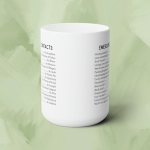 May include: White ceramic mug with black text. The left side of the mug lists a series of names under the heading "CONTACTS:". The right side of the mug lists a series of questions under the heading "EMERGENCIES".