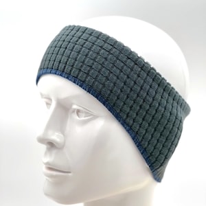 May include: Gray headband with a blue trim. The headband is made of a soft, textured fabric.