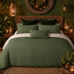 May include: A bedding set featuring a dark green quilt and matching pillow shams with a small-scale white floral vine pattern. The set includes two rectangular pillows and one smaller lumbar pillow, all displayed on a bed with a white sheet.