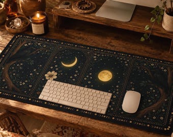 May include: A rectangular desk mat featuring a dark navy blue background with a celestial theme. The design includes arched panels displaying a crescent moon, a full moon, stylised trees, and small white flowers, bordered by golden dots.
