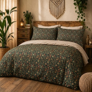 May include: A bedding set featuring a dark green duvet cover and two matching pillowcases adorned with a dense, multi-coloured floral pattern. The set includes a solid light beige top sheet folded over the edge of the dark floral duvet cover.