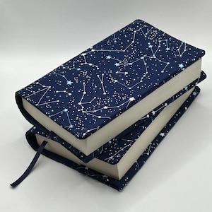 May include: Two navy blue book covers with a white constellation pattern. The covers are stacked on top of each other.