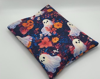 Puede incluir: Un cojín rectangular con un estampado floral azul oscuro con flores naranjas, rojas y amarillas. Ilustraciones de fantasmas blancos están dispersas por la tela. El cojín es probablemente para uso decorativo o funcional.