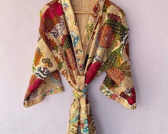 Puede incluir: Una bata beige con estampado floral, ribete blanco y cinturón de anudar. La bata está hecha de una tela suave y acolchada.
