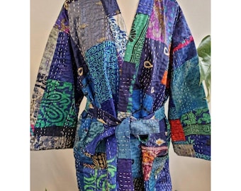 Op de afbeelding: Een blauwe en groene patchwork kimono-jas met een strikceintuur. De jas is gemaakt van een zachte, comfortabele stof en heeft een verscheidenheid aan ingewikkelde patronen.