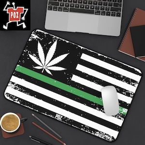 May include: A black and white mouse mat with a green stripe and a marijuana leaf design. The mouse mat has a distressed look and the text "POZ" is printed in the bottom right corner.