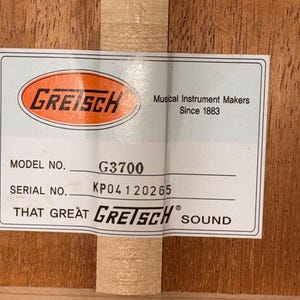 May include: A close-up of a label from a Gretsch musical instrument. The label includes the Gretsch logo, model number G3700, and serial number KP04120265. The text reads "Musical Instrument Makers Since 1883" and "That Great Gretsch Sound."