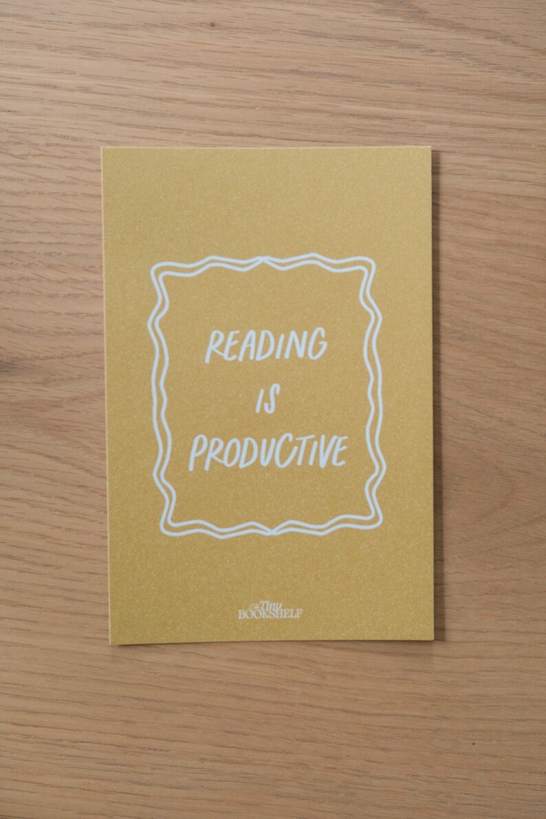 May include: A yellow card with white text that reads "Reading is Productive" inside a white decorative frame. The text "Tiny Bookshelf" is at the bottom of the card.