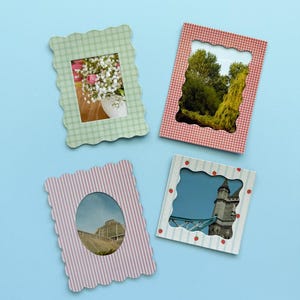 May include: Four decorative picture frames with scalloped edges. The frames feature different patterns: green gingham, red gingham, pink stripes, and white with strawberry accents. Each frame holds a different image, including flowers, trees, and a building.