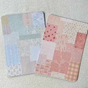 May include: Two cards with a patchwork design. The card on the left has a blue and white patchwork design. The card on the right has a pink and white patchwork design.