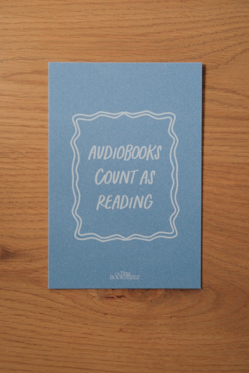 May include: A blue card with white text that reads "Audiobooks count as reading" in a decorative frame. The bottom of the card has the text "The Bookshelf" in white.